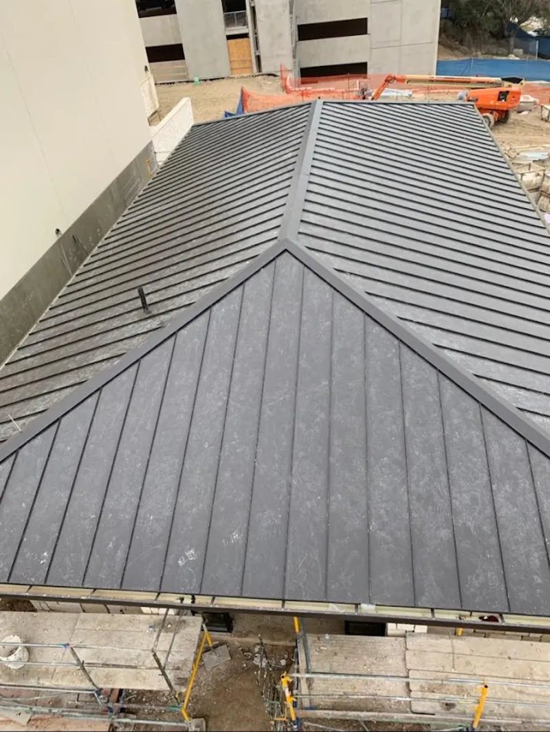 Commercial metal roof construction with crane equipment in Weslaco